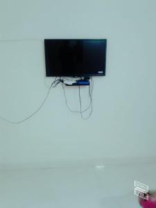 a television hanging on a wall in a room at Roj Cottage in Mount Ābu