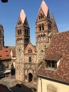 an old church with two towers and a building at LE PIED A TERRE SELESTADIEN in Sélestat