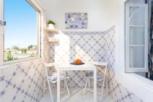 una pequeña mesa y sillas en una habitación con ventana en Crilu, en Lisboa