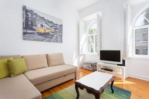 a living room with a couch and a tv at Crilu in Lisbon