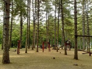 a park with two playgrounds in the trees at Apartman Jovana Sokobanja in Soko Banja