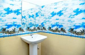 baño con lavabo y palmeras en la pared en Gems Moon Paradise, en Ella