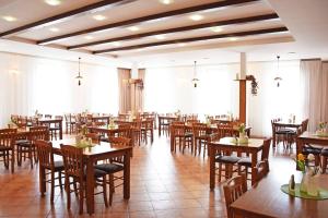 a restaurant with wooden tables and chairs and windows at Penzion U Kostela in Újezd