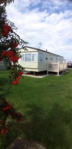 a white house with a porch and a yard at 8 Berth on The Grange (Summer) in Ingoldmells