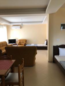 a living room with a couch and a living room with a table at Hotel Villa Ago in Përmet