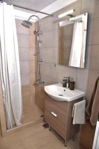 y baño con lavabo y ducha. en Cozy, newly renovated apt near the City Center, en Atenas