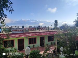 a building with a sign on the top of it at Hotel Deepraj, Kausani in Kausani