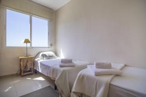 a white room with two beds and a window at Villas Guzman - Apartamento Bellissimo in Moraira