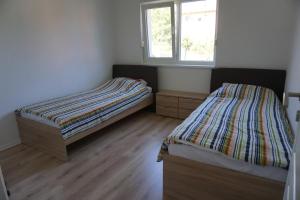 1 dormitorio con 2 camas y ventana en Villa ‘Stone Chair’ in Sarajevo, Vogosca en Vogošća