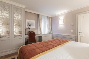 een slaapkamer met een bed, een bureau en een stoel bij La Dimora di San Maurizio 1- Dimora Italia - in Venetië