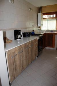 uma cozinha com armários de madeira e uma bancada em KALENA 4 Playa Bonita DAT em San Carlos de Bariloche