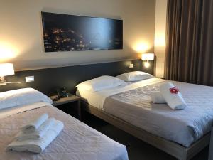 two beds in a hotel room with towels on them at La Sosta Motel Tavola Calda in Matera +47 photos