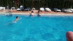 un grupo de personas nadando en una piscina en Hotel Valsequillo, en Lepe