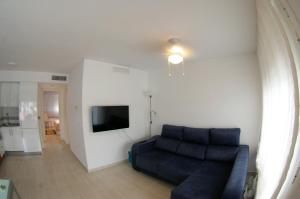 sala de estar con sofá azul y TV en ¡¡NAUTILUS HIGH QUALITY!!, en Carboneras