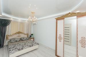 een slaapkamer met een bed en een spiegel bij De LUXE apartments Centr 1 floor in Sumy
