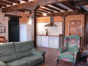 a living room with a couch and a kitchen at Las casas de Yagüe, Ayllón in Santa María de Riaza