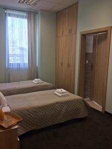 a hotel room with two beds and a window at 3Rooms in Kraków