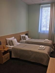 um quarto de hotel com duas camas e uma janela em 3Rooms em Cracóvia