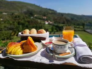 a breakfast table with a cup of coffee and pastries at Casa da Eira in Cabeceiras de Basto