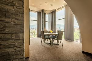 a dining room with a table and chairs and windows at Budapest Hotel - Free Parking in Sofia