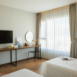 a hotel room with a desk and a window at Em Oi Boutique Hotel in Nha Trang