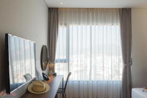 a room with a desk with a large window at Em Oi Boutique Hotel in Nha Trang