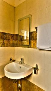 Un baño con un lavabo y un espejo en la pared. en Nandu Hospitality Apartments Services - Aashiyana, en Bangalore 23 fotos más