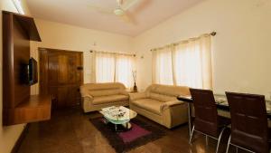 una sala de estar con un sofá y una mesa en Nandu Hospitality Apartments Services - Aashiyana, en Bangalore