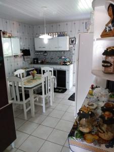 a kitchen with a table and chairs and a refrigerator at Joelma temporada in Maragogi