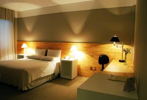 um quarto de hotel com uma cama e uma mesa em Planalto Hotel em Canoinhas