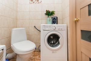 a bathroom with a toilet and a washing machine at Luxury apart-hotel on Kharkovskaya New Building 6 floor in Sumy +22 photos