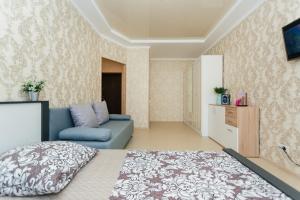a bedroom with a blue bed and a couch at Luxury apart-hotel on Kharkovskaya New Building 6 floor in Sumy