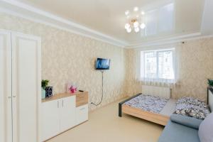 a small room with a bed and a tv on the wall at Luxury apart-hotel on Kharkovskaya New Building 6 floor in Sumy