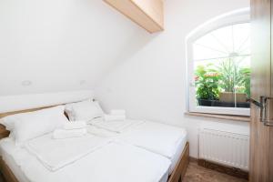 a white bed in a room with a window at Apartments Grad Kamen in Begunje na Gorenjskem
