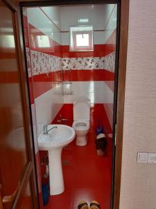 een rood-witte badkamer met een toilet en een wastafel bij Green Villa Nizami in Gabala
