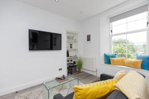 Dollar Apartments-39 Bridge Street في دولار: غرفة معيشة مع أريكة وتلفزيون