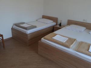 two twin beds in a room with a table at Apartments Beg in Rab