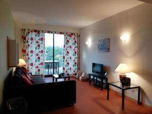 sala de estar con sofá y TV en Residence Golf Club - Apartamento 322, en Vilamoura