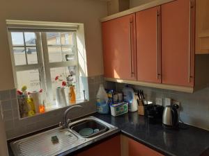 a kitchen counter with a sink and a window at Double Room in Honiton House in Hendon