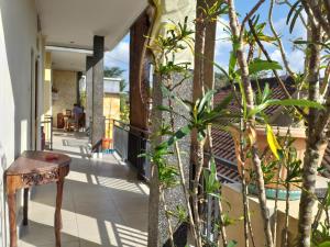 un balcón de una casa con un banco y árboles en Puri Asri Bungalow Ubud, en Ubud