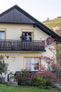 two people looking out the window of a house at Privatzimmer Haring in Kitzeck im Sausal