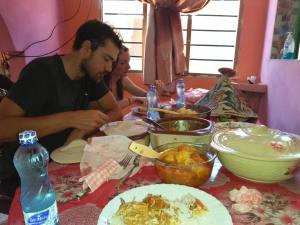 Wasini的住宿－Wasini Raha Snorkeling and Diving，坐在餐桌旁吃饭的男人和女人