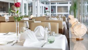 a table with a white table cloth with a rose on it at Hotel Der Seehof in Ratzeburg