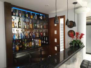 a bar with a lot of alcohol bottles on the wall at Villas Hotel in São Paulo