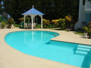 a swimming pool with a gazebo in a yard at Casa Marina- Flic en Flac - Beach is right in front of the Villa-Just cross the road in Flic-en-Flac