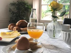 une table avec un verre de jus d'orange et une assiette de nourriture dans l'établissement Le Cœur de la Bastide - Adult only, à Carcassonne