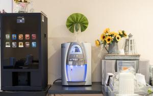 een bureau met een computer en een printer en bloemen bij Melandre Hotel By Saba in Londen