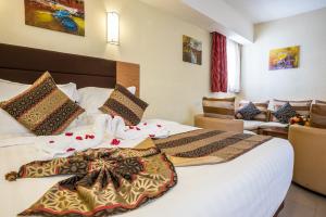 a hotel room with a large bed and a couch at PrideInn Hotel Mombasa City in Mombasa