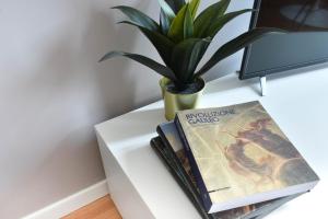 a table with two books and a potted plant on it at Welc-oM Casa Anna in Padova