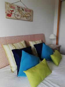 Una cama con almohadas azules y verdes. en Residence Golf Club - Apartamento 322, en Vilamoura